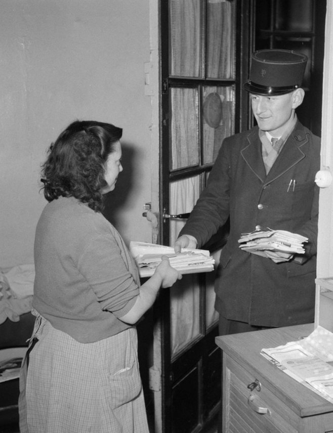 PTT : un facteur apportant du courrier à une concierge en 1954